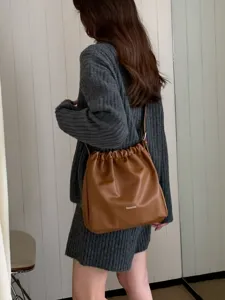 Casual pleated cloud crossbody bucket bag, stylish brown leather shoulder bag detail view.