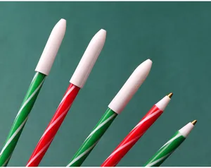 Detail shot of Christmas candy cane ballpoint pens with red and green spiral patterns.