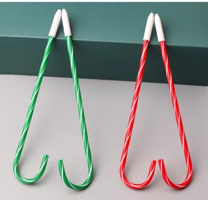 Close-up detail of creative Christmas candy cane ballpoint pens with striped design and white caps.