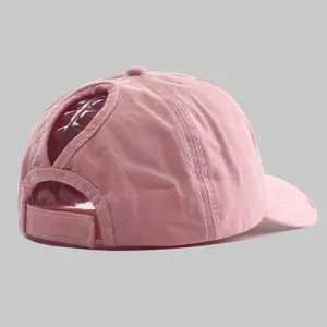 Pink distressed washed ponytail baseball cap with convenient back hole and adjustable strap.