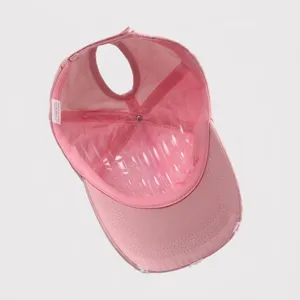 Detail view of the pink distressed ponytail baseball cap showing inner wash tag and structure.