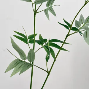 Close-up view of artificial bamboo branches with green leaves, zen indoor decor plant.