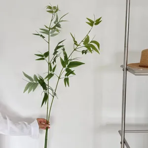 Close-up detail of artificial green bamboo leaves branch, perfect for interior decor.
