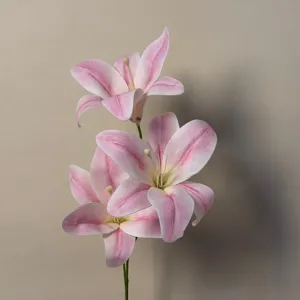 Closeup of pink artificial lily flower branch detail, realistic silk floral arrangement.