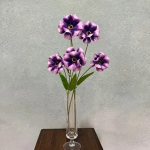 Vista di dettaglio di 5 teste di ranuncoli artificiali viola in vaso di vetro per decoro.