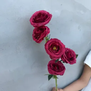 Detaillierte Nahaufnahme von dunkelroten künstlichen Rosen mit realistischen Blättern.