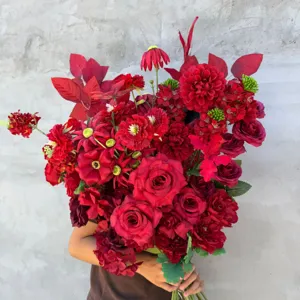 Detailansicht eines künstlichen roten Blumenstraußes mit lebendigen Rosen und grünem Laub.