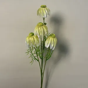 Primo piano di un ramo di fiore artificiale con petali bianchi pendenti e foglie verdi.