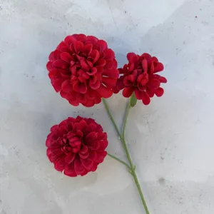 Nahaufnahme des künstlichen roten Dahlien-Seidenblumen-Zweigdetails für Hochzeitsdeko und Kunst.