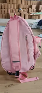 Detail view of the pink sling racket backpack, featuring zipper and side mesh pockets.