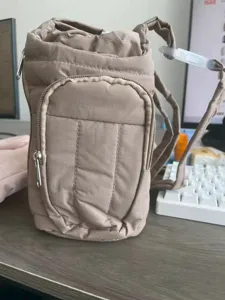 Borsa per bottiglia d'acqua trapuntata cachi con tracolla regolabile e tasca frontale.