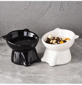 Vue detaillee de gamelles pour chats surelevees et inclinees en ceramique noire et blanche.