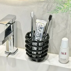 Porte-brosse à dents moderne en céramique noire, organiseur tressé pour lavabo de salle de bain.