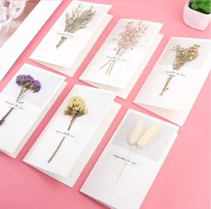 Detailed shot of handmade dried flower greeting cards with natural botanical elements for gifts.
