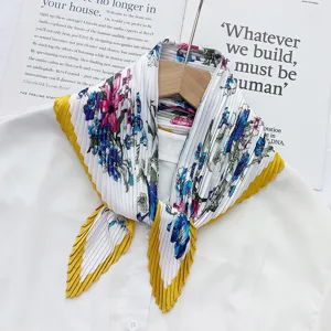 Detailed view of pleated floral scarf with vibrant blue pink pattern and yellow border accents.