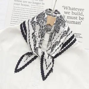 Pleated scarf detail showcasing the elegant black and white floral print and texture.