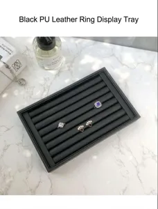 Vue détaillée du plateau de présentation de bague en cuir PU noir avec des bijoux.