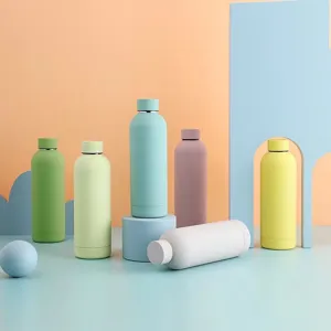 Detail shot of colorful stainless steel insulated water bottles in a pastel studio setting.