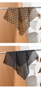 Detailed view of lightweight square scarves with floral and polka dot patterns, hanging on a display.