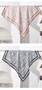 Détail de carré de soie à imprimé léopard, matière élégante au toucher doux, accessoire mode.