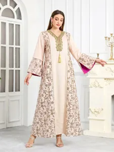 Dettagli dell'elegante abito caftano ricamato di paillettes con scollo a V e nappe.