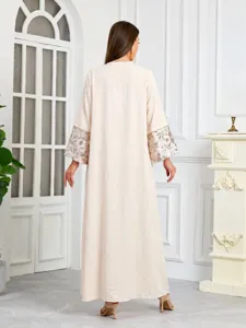 Vista posteriore di elegante caftano beige con raffinati polsini ricamati di paillettes.