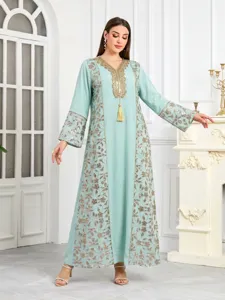 Abito lungo caftano verde menta con elegante ricamo dorato, paillettes e dettaglio nappina.