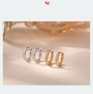 Primer plano detalle de pendientes de aro en plata de ley 925 con circonitas brillantes.