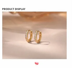 Primer plano detallado de pendientes de aro de plata esterlina con circonitas brillantes.