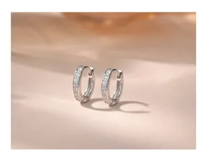 Vista detallada de pequeños pendientes de aro en plata de ley S925 con circonitas.
