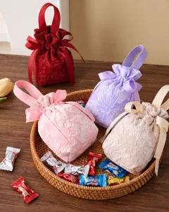 Detailed view of elegant fabric candy gift bags with drawstring and bow for wedding party decor.