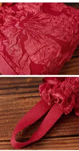 Closeup detail of the red textured fabric wedding candy bag handle and crinkled surface texture.