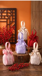 Detailed view of fabric candy gift bags with exquisite floral brocade and cute bow ribbon handles.