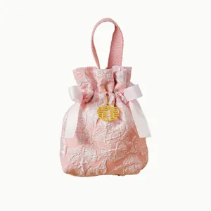 Pink wedding candy pouch made of brocade fabric with double happiness charm and ribbon.