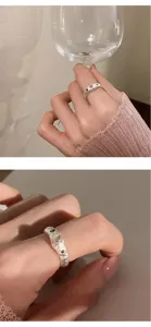 Detailaufnahme des unregelmässigen Lava-Strukturrings mit rosa Herz-Edelstein und Kunststil.