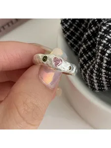 Detailansicht des unregelmäßigen strukturierten offenen Rings mit rosa Herz und Steinen.