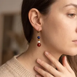 Orecchini pendenti con perle in pietra naturale e cerchio in acciaio inossidabile.