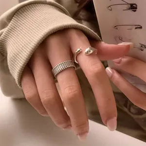 Close-up detail of Korean niche design open ring, sterling silver texture geometric water drop style.