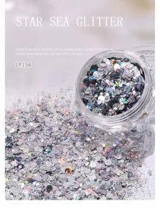 Nahaufnahme von gemischten Nagelglitterflocken im transparenten Glas, glitzernde Textur.