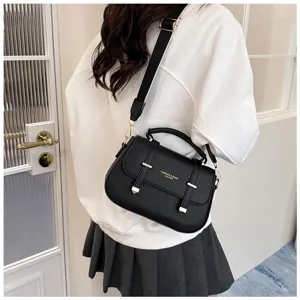 Detailed shot of a black PU leather saddle bag with double strap design and wide shoulder strap.