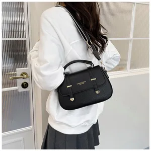 Detailed view of women's black leather saddle bag with gold metal hardware and shoulder strap.