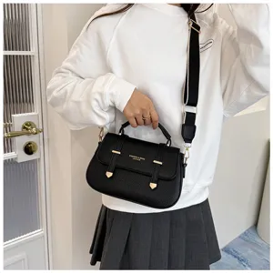 Detailed view of black leather crossbody saddle bag with top handle and wide strap.