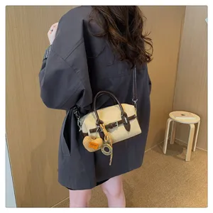 Gedetailleerd overzicht van de retro suède Boston tas met contrasterend design en schouderriem.