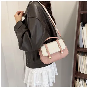 Detailed view of the stylish pink and white color block leather handbag with double strap design.