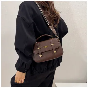 Detail view of retro brown leather saddle bag with double strap design and top handle.