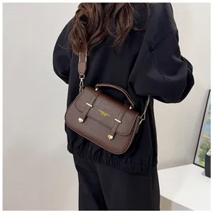 Close-up detail of retro brown leather saddle bag featuring dual strap buckles and handle.