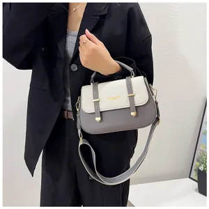Women's two-tone saddle bag with double belt straps, chic crossbody handbag for daily use.