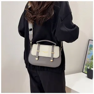Retro two-tone leather crossbody saddle bag for women with stylish double strap and top handle.