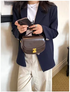Primer plano detallado del bolso tipo silla marrón retro con cierre metálico elegante.