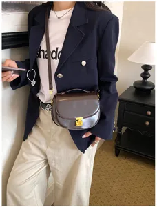 Clásico bolso de silla de montar retro marrón con cerradura dorada, diseño elegante de hombro.